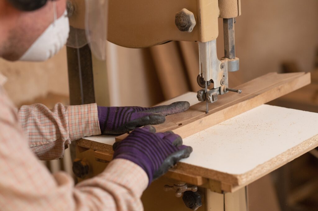 Carpentry worker using band saw in a woodworking workshop